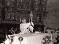 Clérigo levantando la custodia durante los actos religiosos del aniversario de la Adoración Nocturna, en el interior de la iglesia parroquial de San Miguel