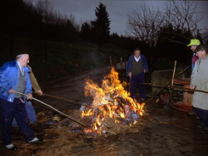 [Txerriaren azala erretzeko gariaren lastoari su ematen]