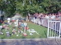 Espectadores junto a los trofeos y premios del campeonato de tiro al plato