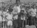 Pastor con trofeos junto a niño