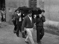 Amigos del fallecido llevando el féretro a hombros a la salida de la iglesia