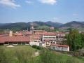 Vista parcial de Oñati : en primer plano el polideportivo, el mercado, la plaza de los Fueros y la iglesia parroquial de San Miguel. Al fondo, la torre de Zumeltzegi