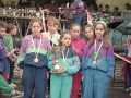 Grupo de niñas con medallas y un trofeo