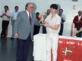 Actos de entrega de trofeos de las finales de pelota vasca de la Cuenca del Deba. Al fondo, entre las personas que se encuentran junto a la pared del frontón, Eli Galdos