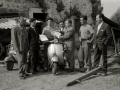 GRUPO DE HOMBRES ENTREGANDO UN PREMIO EN METALICO EN EL EXTERIOR DE UN CASERIO. (Foto 4/5)