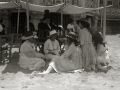 GRUPOS DE PERSONAS BAJO LOS TOLDOS EN LA PLAYA DE LA CONCHA. (Foto 1/2)