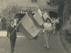 Momento del desfile en el que dos jóvenes llevan la bandera con el escudo de Gipuzkoa