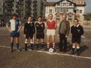 Trío arbitral y capitanes de ambos equipos de fútbol al comenzar el partido en la zona deportiva