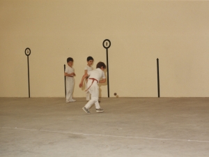 Niños jugando un partido de pelota para inaugurar el frontón cubierto