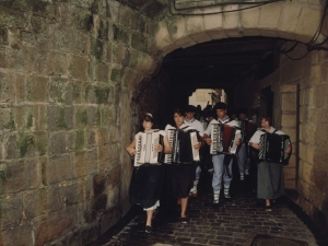 Grupo de músicos que preceden a la comitiva, pasando bajo los arcos de la calle San Juan
