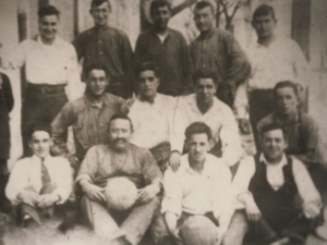 Catorce chicos posando con un par de balones de fútbol