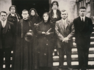 El párroco y un grupo de personas posando a la salida de misa en las escaleras de la iglesia de Pasai Antxo