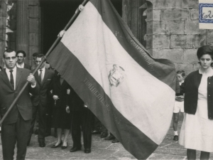 Desfile de la bandera hacia el Ayuntamiento. Al fondo se ve la entrada a la iglesia de San Juan Bautista