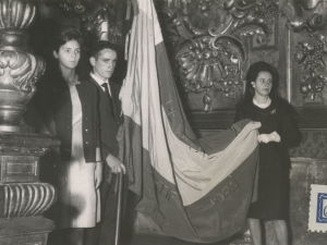 Jóvenes con la bandera conseguida en el interior de la iglesia de San Juan Bautista