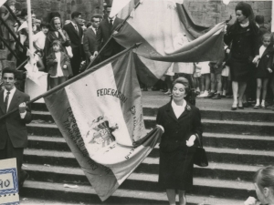 Desfile de las banderas hacia el Ayuntamiento. Al fondo se ve la entrada a la iglesia de San Juan Bautista