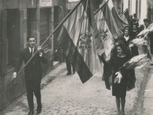 Desfile de las banderas, a la altura de calle San Juan 31, hacia la iglesia de San Juan Bautista