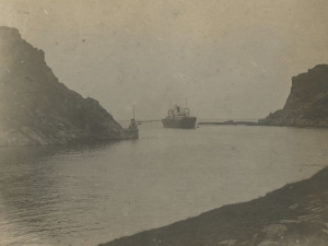 Barco entrando por la bocana de la bahía de Pasaia entre las rocas de Arando Txiki y Arando Aundi