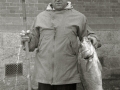 HOMBRE CON SUS CAÑAS DE PESCAR MOSTRANDO LAS PIEZAS CAPTURADAS. (Foto 2/2)