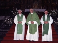 El sacerdote Juan Mujika y otros dos clérigos a sus lados en la iglesia parroquial de San Miguel