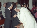 Actos religiosos en homenaje a dos monjas : un clérigo besa a una de las religiosas homenajeadas
