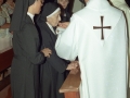 Actos religiosos en homenaje a dos monjas : un clérigo da la comunión a una de las religiosas homenajeadas