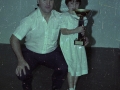 Señor junto con una niña que sostiene uno de los trofeos en el homenaje al pelotari Agiriano