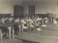 Niños y niñas en sus clases con la maestra en la nueva escuela de niños de ambos sexos en Mendelu Escuelas de Amute (posteriormente Martínez Anido)