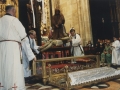 Los sacerdotes introduciendo en la urna de cristal el cuerpo de Cristo en la procesión de Semana Santa
