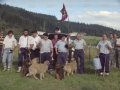 Pastores con sus perros. En el centro, uno de ellos sostiene un trofeo