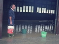 Hombre con cubos para extraer el agua de un pabellón