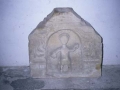 Talla de piedra que representa a un personaje enmarcado en un nicho