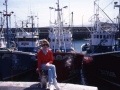 Mari Paz Ibeas sentada frente a los barcos pesqueros del puerto de Hondarribia
