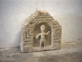Talla de piedra que representa a un personaje enmarcado en un nicho