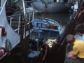 Pescadores recogiendo la red en el barco atracado en el puerto