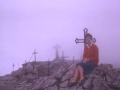 Mari Paz Ibeas Hernio mendi tontorreko botozko gurutzeen ondoan eserita