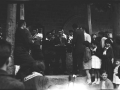Grupo de gente cantando en el pórtico de la iglesia de San Miguel
