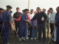 Grupo de personas, entre ellas, Jose Antonio Ardanza saludando a unos carboneros