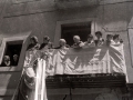 Grupo de mujeres contemplan la procesión del Corpus desde un balcón