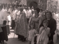 Grupo de mujeres y niñas junto al paso del palio de la procesión del Corpus