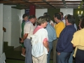 Grupos de personas conversando en una reunión de Eusko Alkartasuna. Se encuentran de espaldas, Carlos Garaikoetxea e Inaxio Oliveri