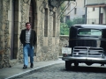 Viandante caminando junto a un automóvil de la película Fiesta